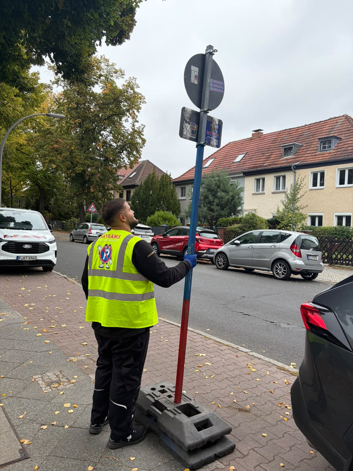 Bayrams-Mitarbeiter mit Halteverbotsschild beim Einsatz